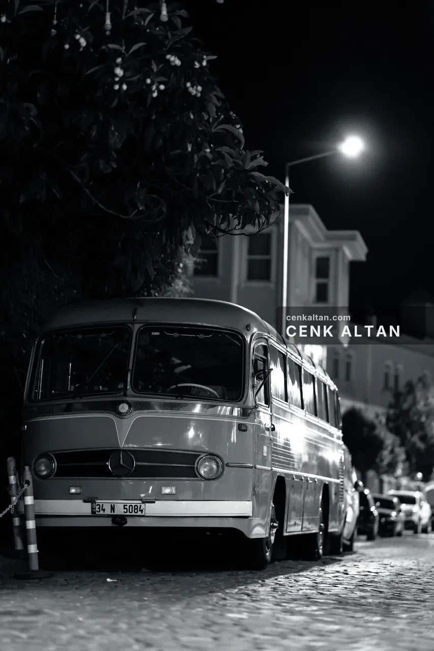 Siyah beyaz: gece bir sokak lambası altında park etmiş eski model bir otobüs