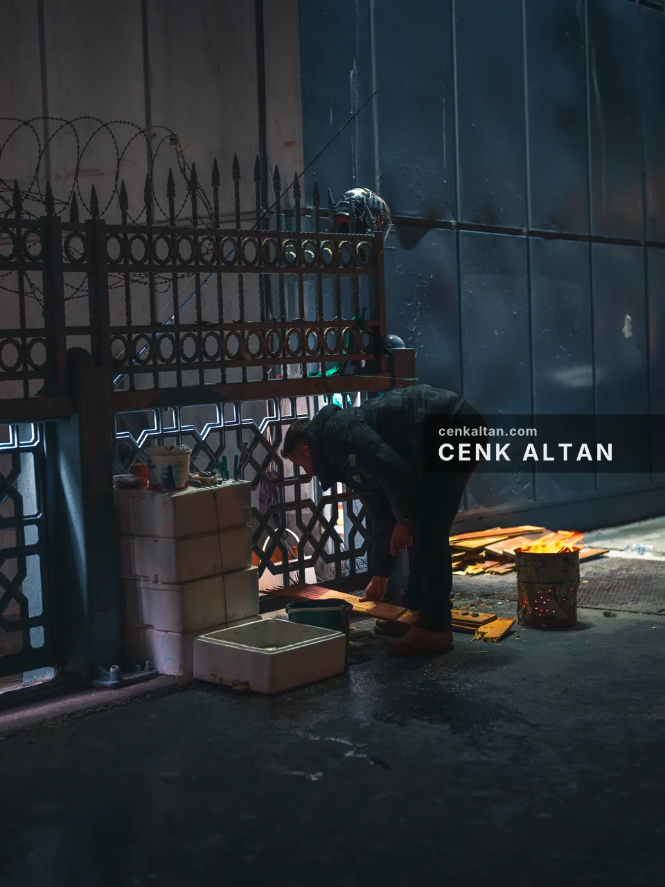 Demir parmaklıklı bir kapının önünde eğilmiş çalışan bir adam