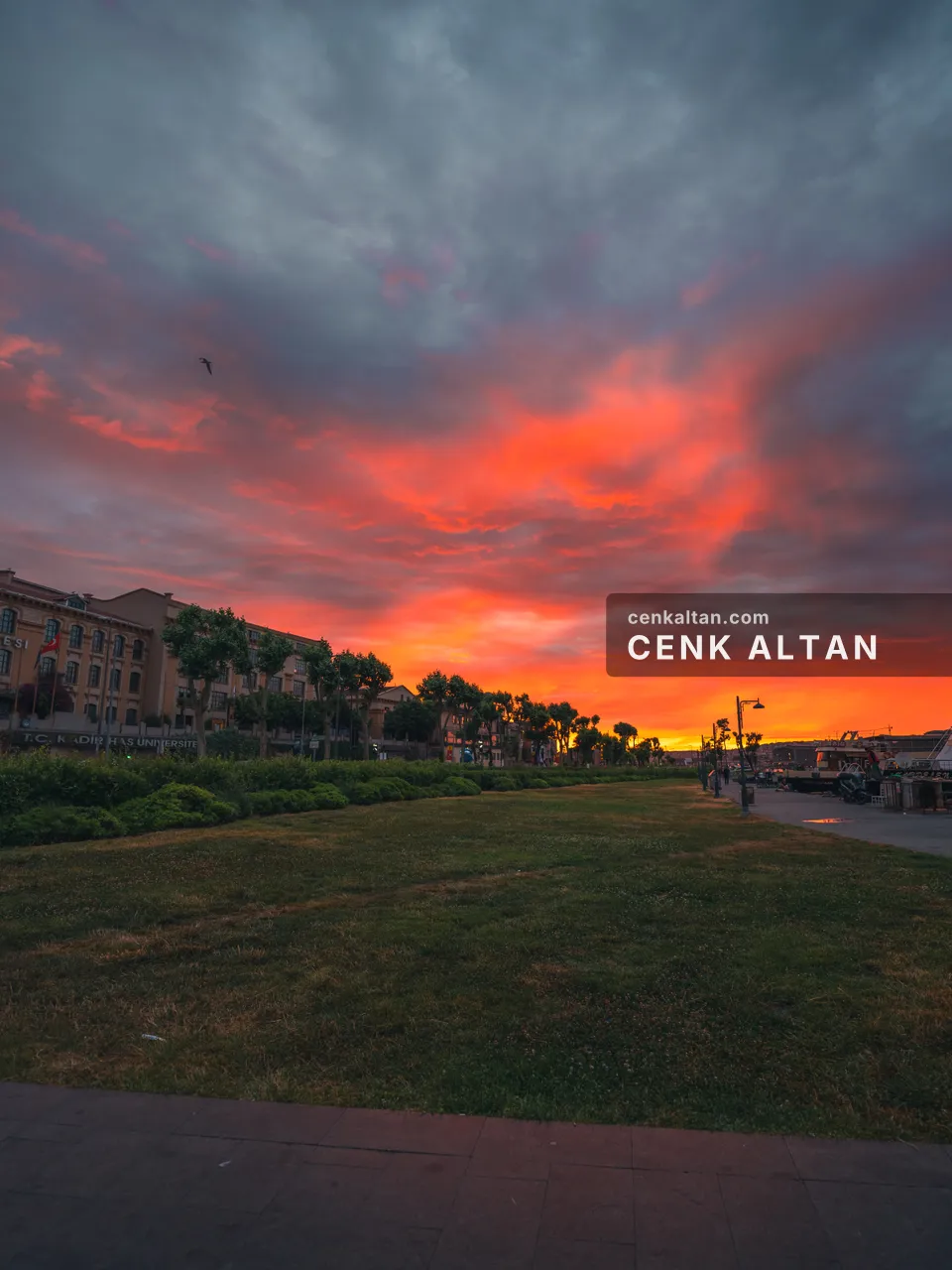 Kızıl bulutlu gün batımı, park ve binalar