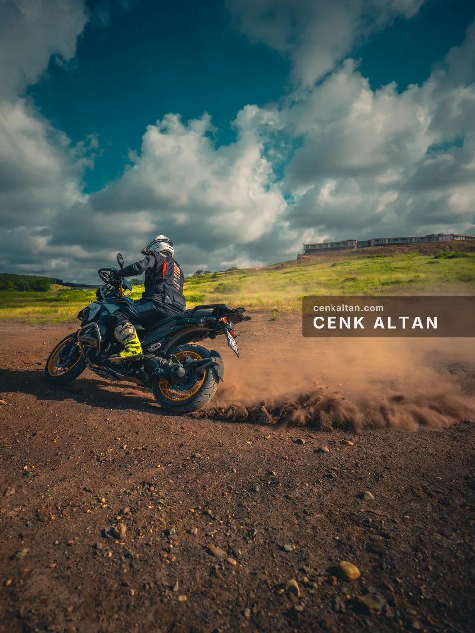 Motosikletli toprak yolda dönüş yaparken kalkan toz