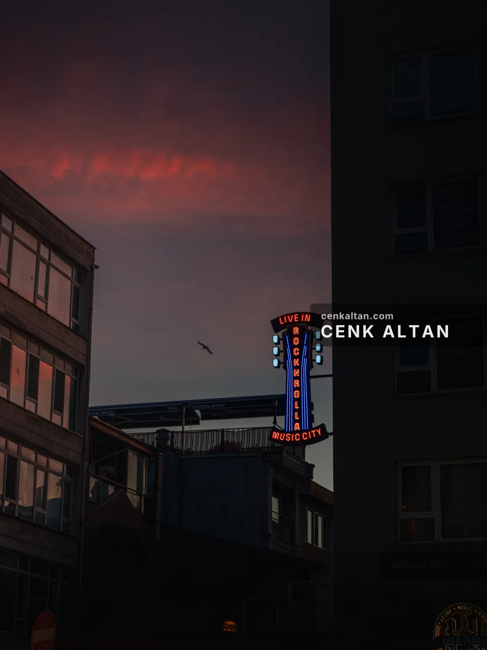 Akşam gökyüzü önünde bina köşesinde neon tabela