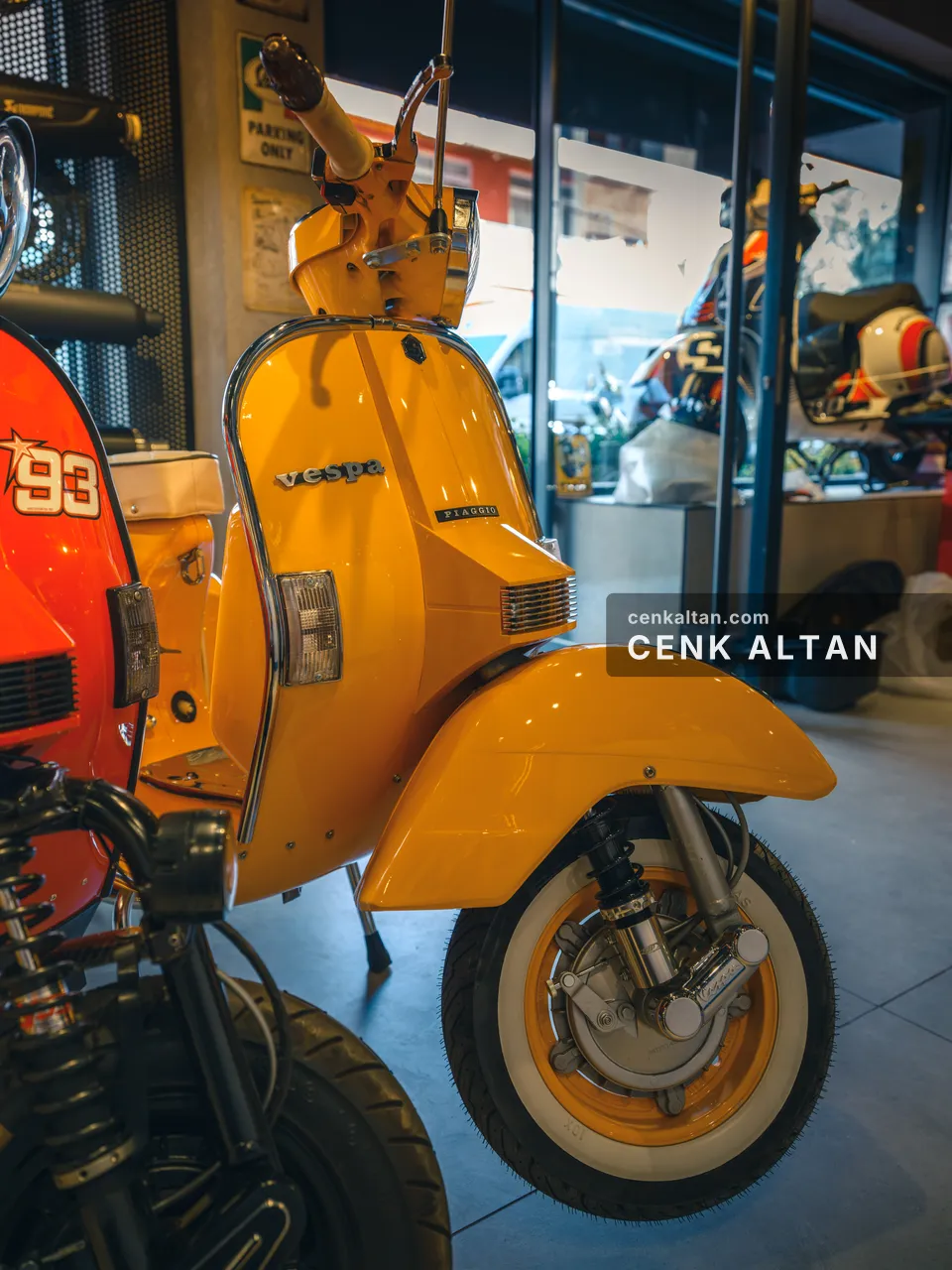 Sarı Vespa ve önde kırmızı motosiklet parçası, yakın plan