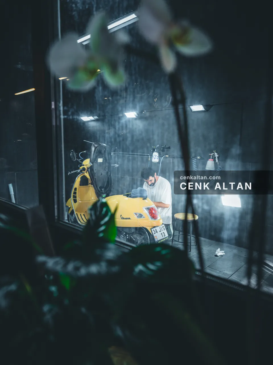 Cam arkasında sarı scooter, önde bulanık beyaz orkide