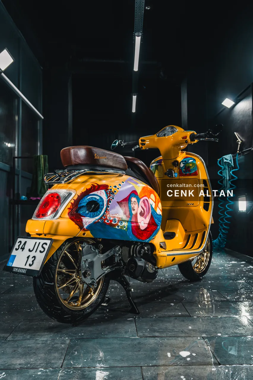 Elle boyanmış sarı Vespa’nın arkadan görünümü
