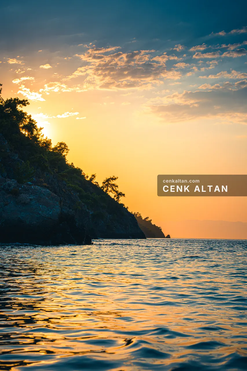 Gün batımında bir burnun silüeti ve parlayan deniz