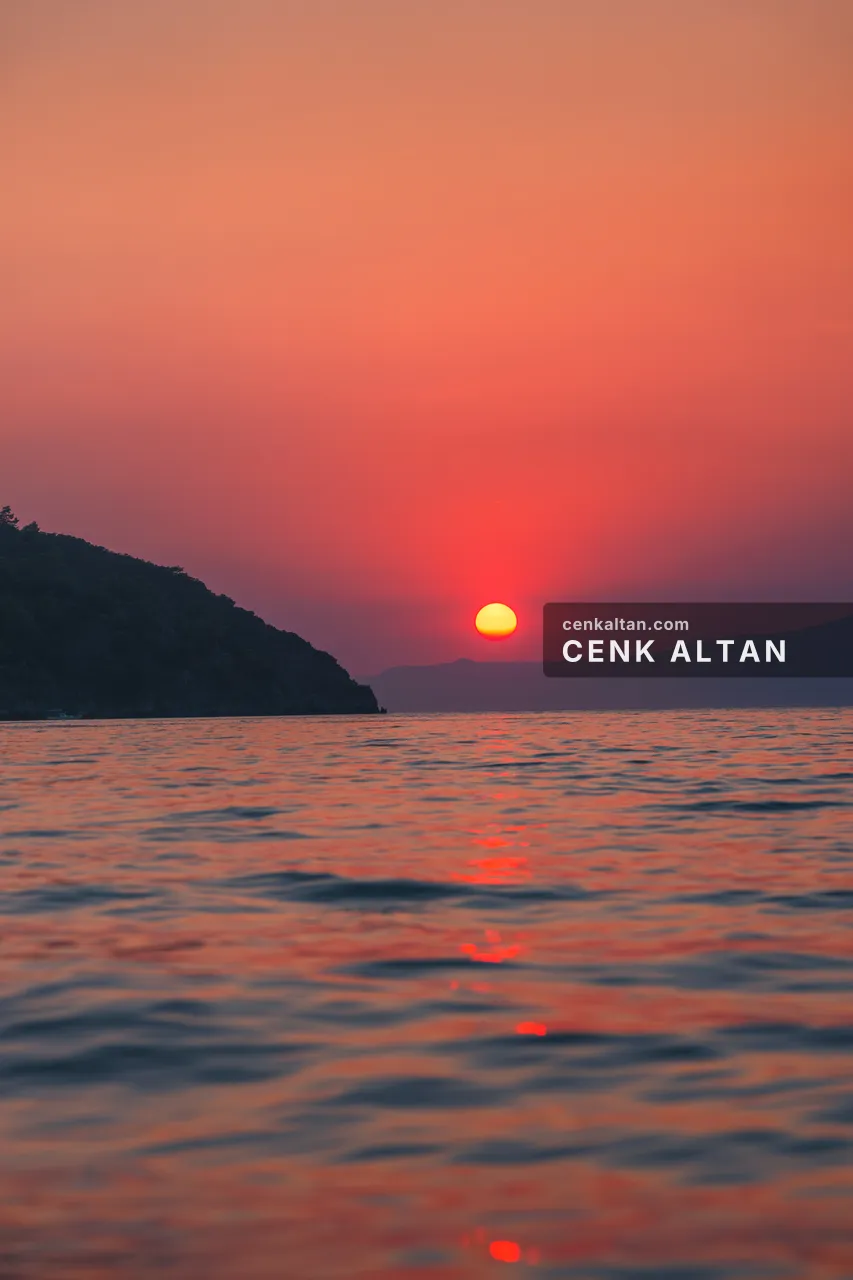 Pembe gökyüzünde batan güneş ve dağ silüeti