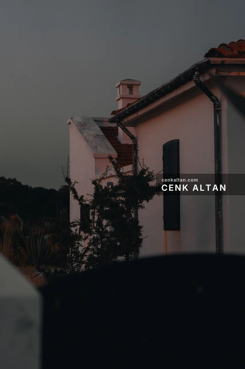 Alacakaranlıkta beyaz taş ev ve bacası